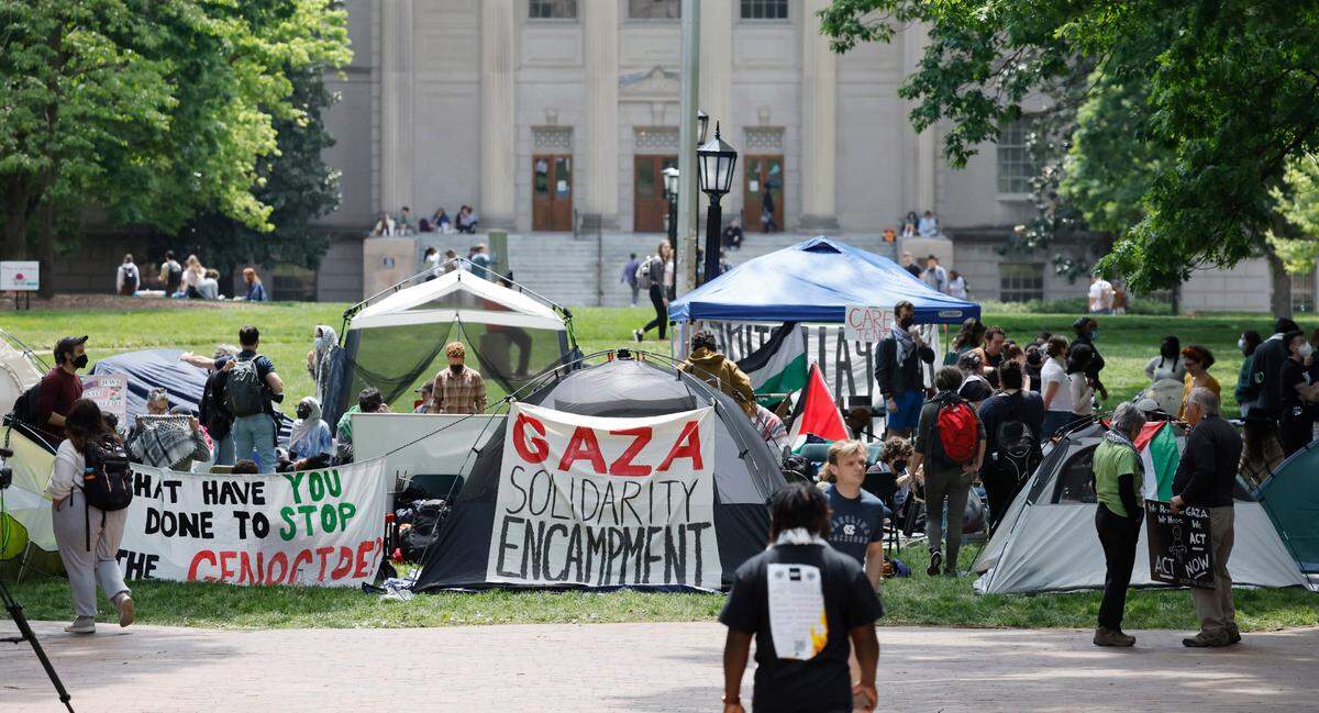 Protesters gather amongst their tents as part of a Gaza Solidarity Encampment at Polk Place on the campus of UNC-Chapel Hill early Friday afternoon, April 26, 2024.