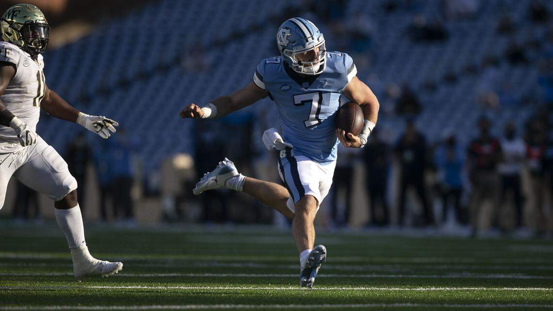 North Carolina quarterback Sam Howell (7) scores the game winning touchdown on a 20-yard carry ahead of Wake Forest’s Miles Fox (11) late in the fourth quarter to give the Tar Heels’ a 52-45 lead. Photo by Robert Willett #unc #samhowell #tarheels #wakeforest #collegefootball #sports #photojournalism