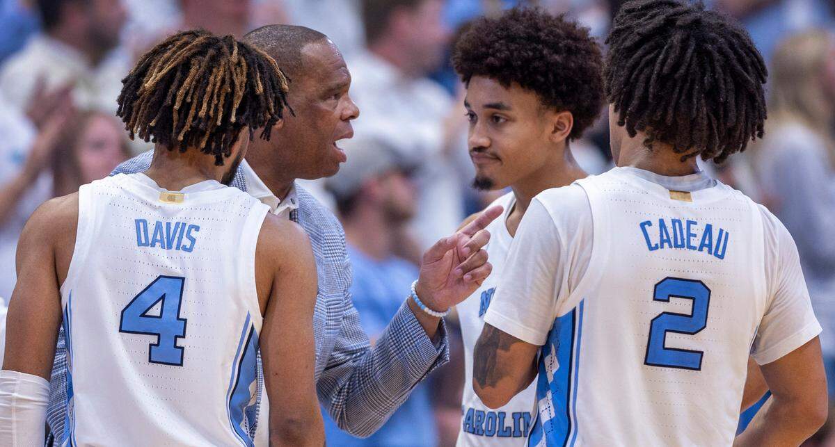 North Carolina coach Hubert Davis huddles with R.J. Davis (4), Seth Trimble (7) and Elliot Cadeau (2) in the closing minutes of play against Tennessee on Wednesday, November 29, 2023 at the Smith Center in. Chapel Hill, N.C.