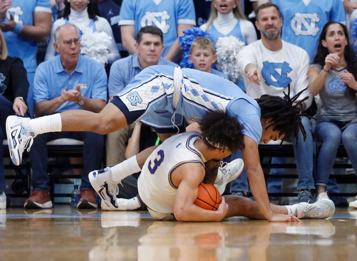 North Carolina’s Elliot Cadeau jumps over UC Riverside’s Isaiah Moses for a loose ball during the first half of the Tar Heels’ 77-52 win on Friday, Nov. 17, 2023, at the Smith Center in Chapel Hill, N.C.