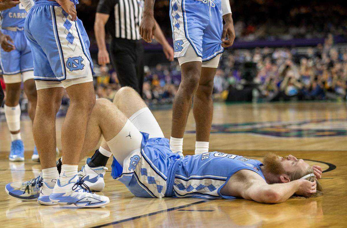 North Carolina’s Brady Manek (45) falls to the court after a collision in the first half against Kansas during the NCAA Championship game on Monday, April 4, 2022 at Caesars Superdome in New Orleans, La.
