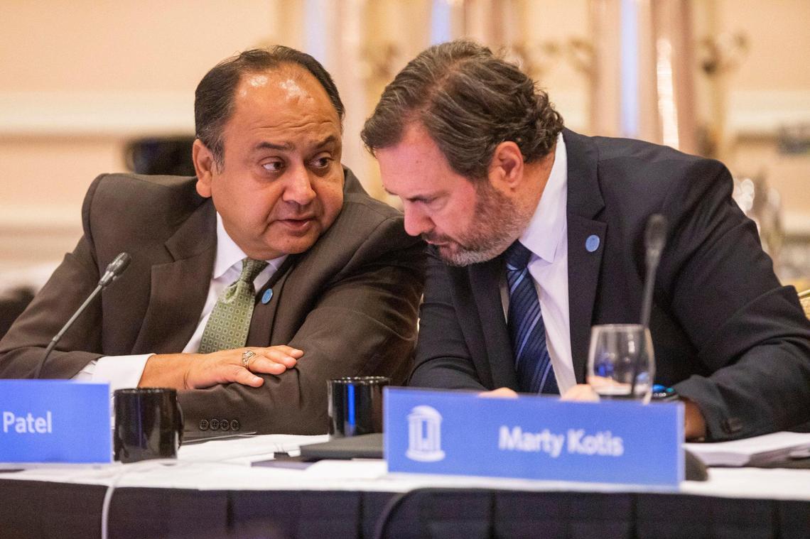 Vinay Patel, left, whispers to Marty Kotis during their first meeting as a members of the UNC Board of Trustees, at the Carolina Inn, on Thursday, July 15, 2021, in Chapel Hill, N.C.