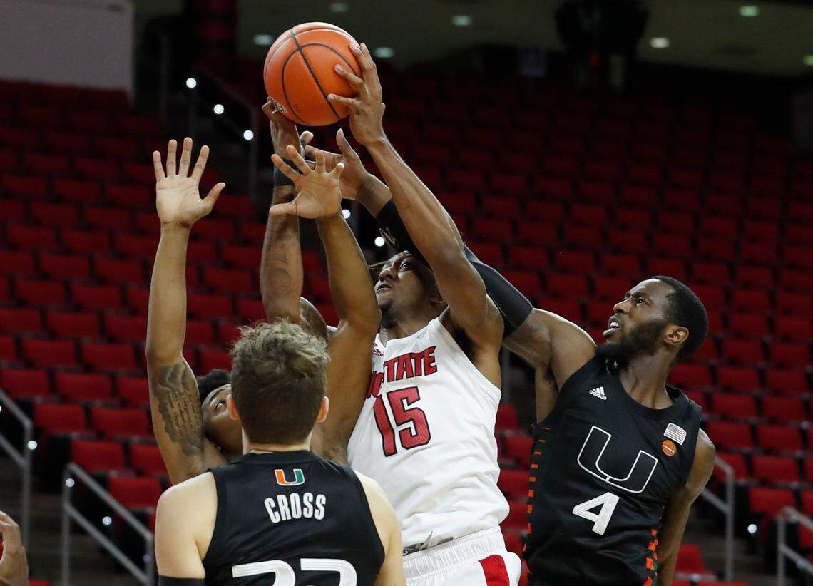 N.C. State’s Manny Bates (15) pulls in the rebound from Miami’s Elijah Olaniyi (4) during the first half of N.C. State’s game against Miami at PNC Arena in Raleigh, N.C., Saturday, January 9, 2021.