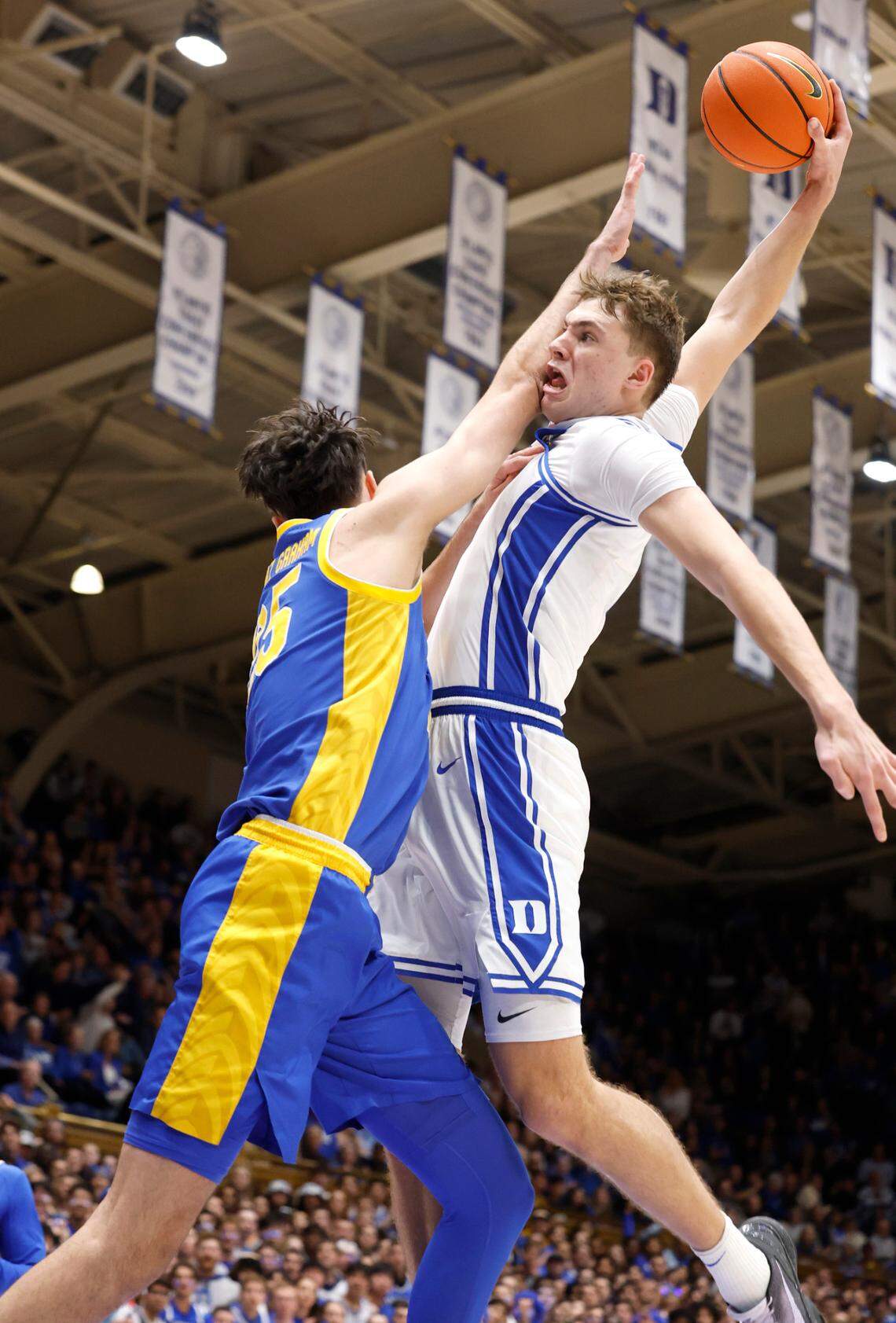 Duke’s Cooper Flagg (2) heads to slam in two while being fouled by Pittsburgh’s Guillermo Diaz Graham (25) during the second half of Duke’s 76-47 victory over Pitt at Cameron Indoor Stadium in Durham, N.C., Tuesday, Jan. 7, 2025.