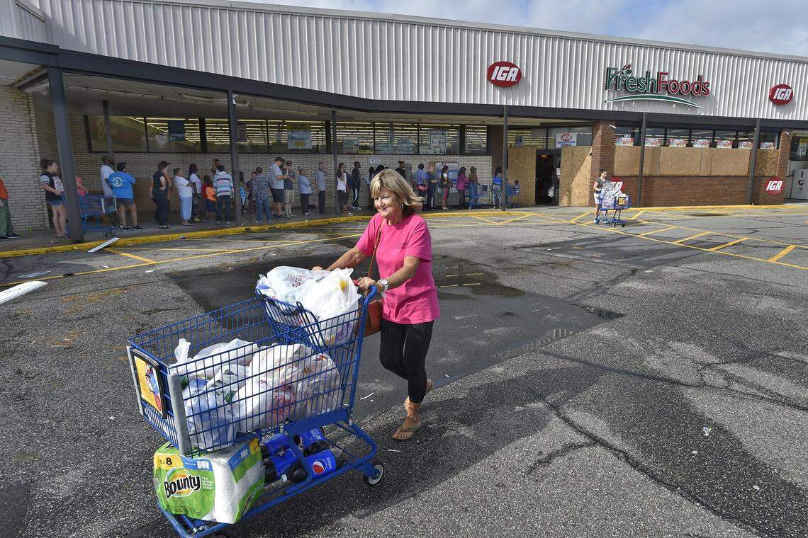 People in Lumberton, NC, were more than happy to stand in line Monday morning as many businesses in the area re-opened after being closed due to Tropical Storm Florence. Vickie Pittman, above, walked to her car after filling a shopping cart at the IGA store on N.C. Highway in Lumberton. “It’s fantastic, we needed things,’’ she said.