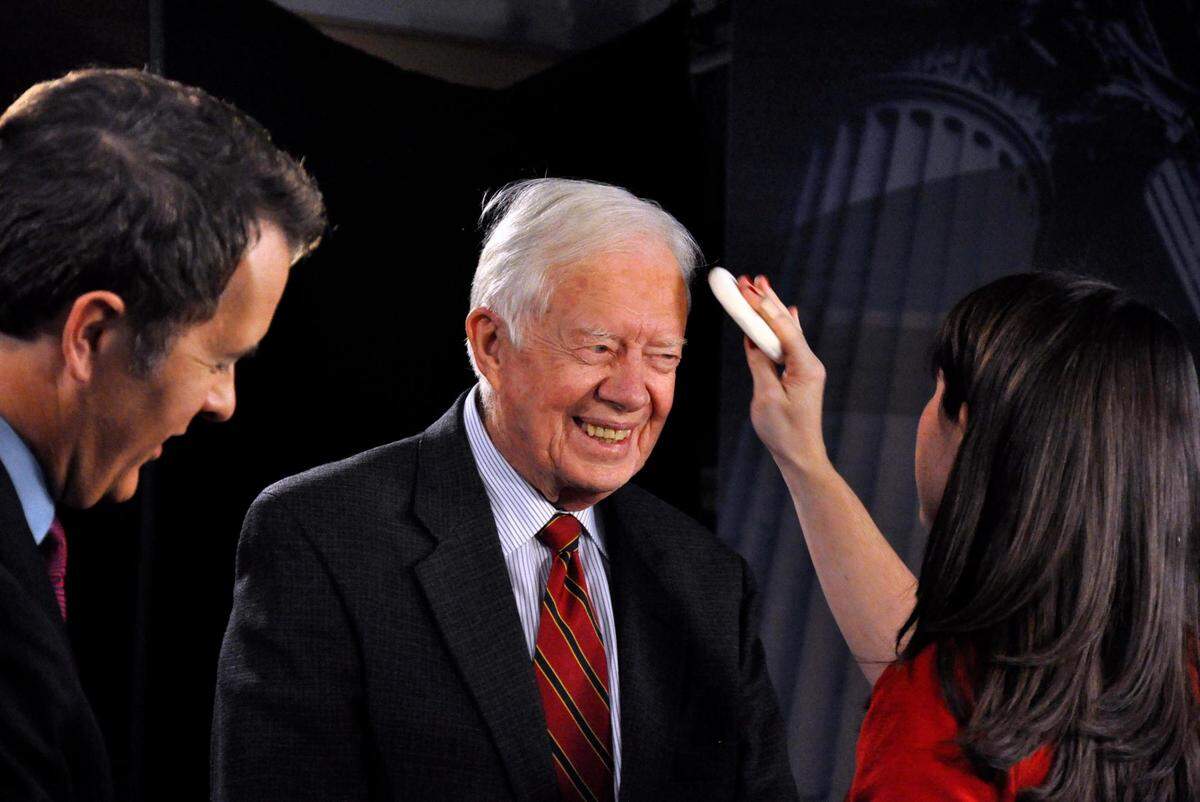 Former President Jimmy Carter jokes with WCNC staff in Charlotte while getting makeup applied before a taped interview in January 2009. Carter was in town to sign copies of his book, “We Can Have Peace in the Holy Land” at a Walmart in Charlotte.