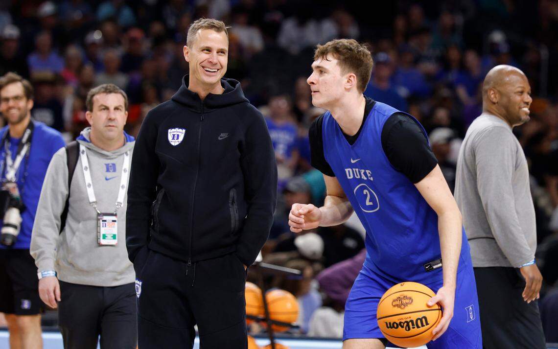 Duke head coach Jon Scheyer smiles as Cooper Flagg (2) drives past him during Duke’s practice at the Alamodome in San Antonio, Texas, Friday, April 4, 2025.