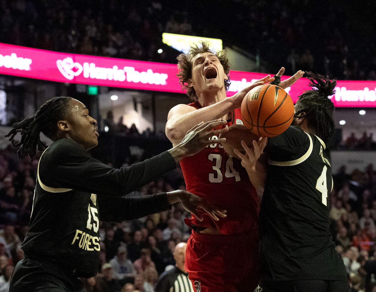 N.C. State’s Ben Middlebrooks is fouled as he drives to the basket between Wake Forest’s Tre’Von Spillers and Efton Reid III during the first half of the Wolfpack’s game on Saturday, Jan. 4, 2025, at Lawrence Joel Veterans Memorial Coliseum in Winston-Salem, N.C.
