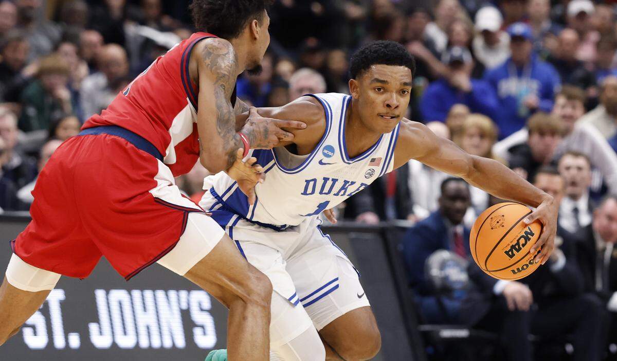 Duke’s Caleb Foster (1) drives by St. John's Dillon Mitchell (1) during the second half of Duke’s 80-75 victory over St. John’s in the Sweet 16 of the NCAA Men’s Basketball East Regional at Capital One Arena in Washington, D.C., Friday, March 27, 2026.