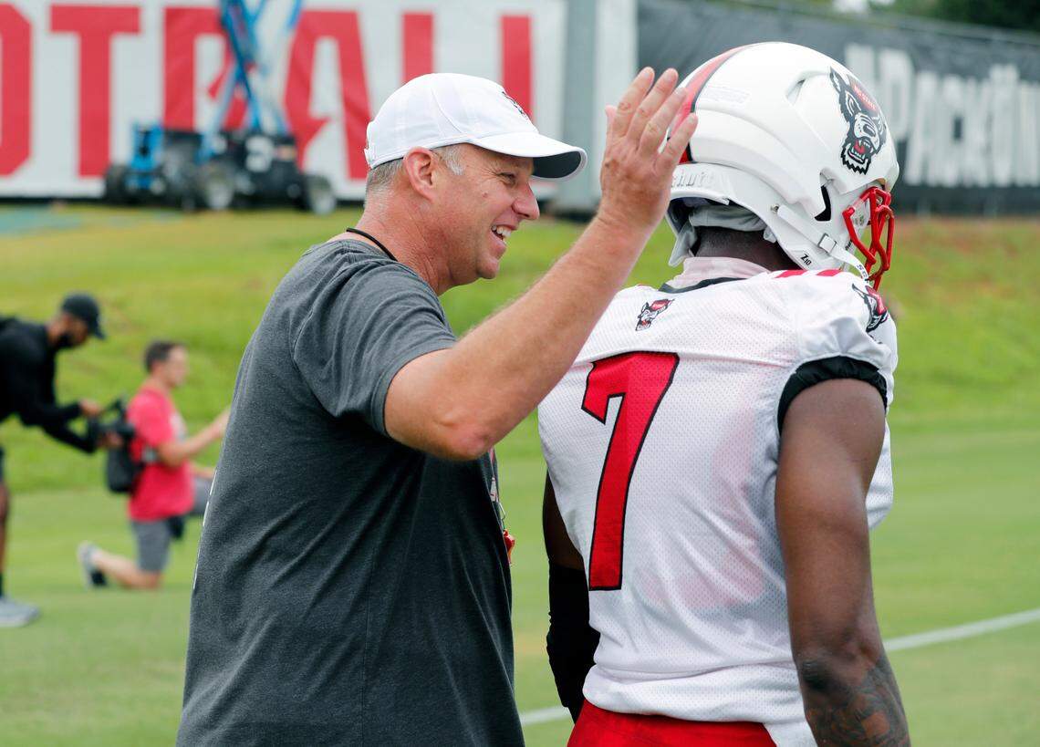 N.C. State head coach Dave Doeren congratulates cornerback Chris Ingram (7) on his play during the Wolfpack’s first practice of fall camp in Raleigh, N.C., Wednesday, August 4, 2021.