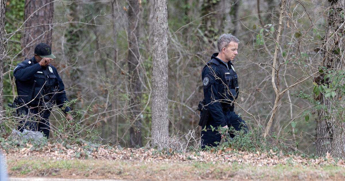 Law enforcement walk in the woods near the intersection of NC-55 and Crete Street on Thursday, Feb. 9, 2023, in Durham, N.C.
