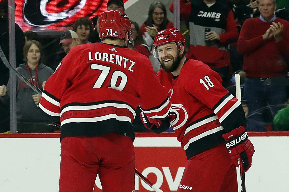 Carolina Hurricanes’ Steven Lorentz (78) hands teammate Derek Stepan (18) the puck which he score a goal and Stephan notched his 500th career point during the second period of an NHL hockey game against the Philadelphia Flyers in Raleigh, N.C., Saturday, March 12, 2022. (AP Photo/Karl B DeBlaker)
