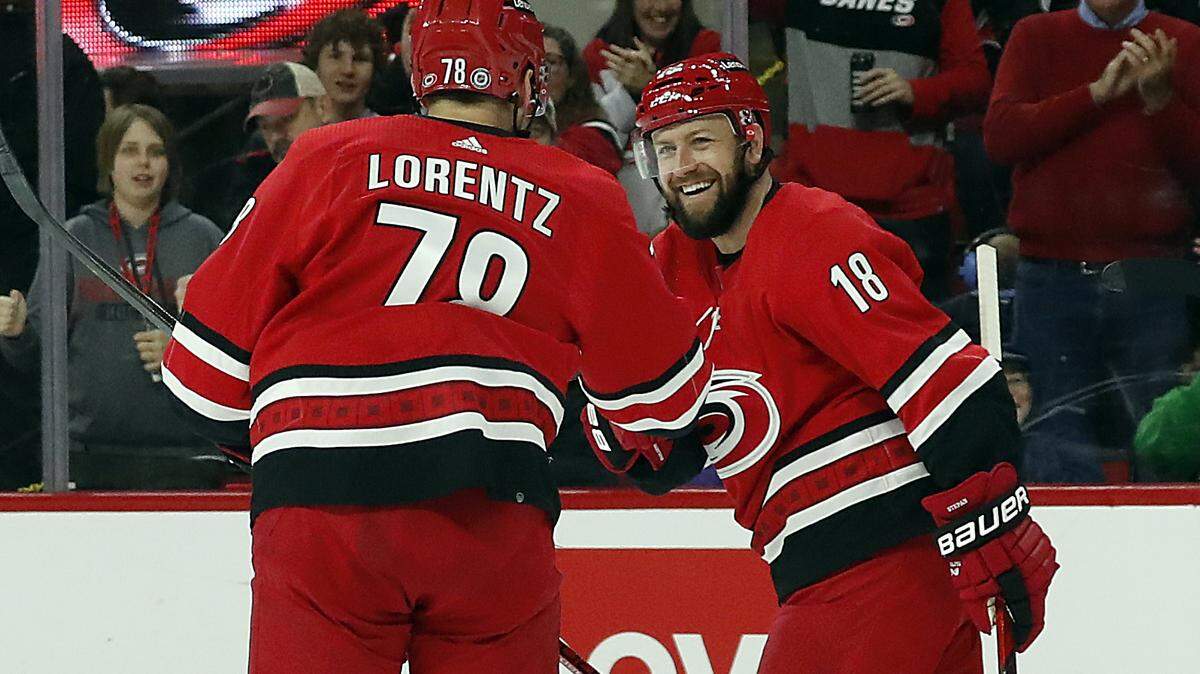 The Carolina Hurricanes’ Steven Lorentz (78) hands teammate Derek Stepan the puck after Stepan scored a goal to notch his 500th career point during the second period against the Philadelphia Flyers in Raleigh, N.C., on Saturday, March 12. Both Stepan and Lorentz have been healthy scratches often in the playoffs, and are biding their time before they can play again. (AP Photo/Karl B DeBlaker)