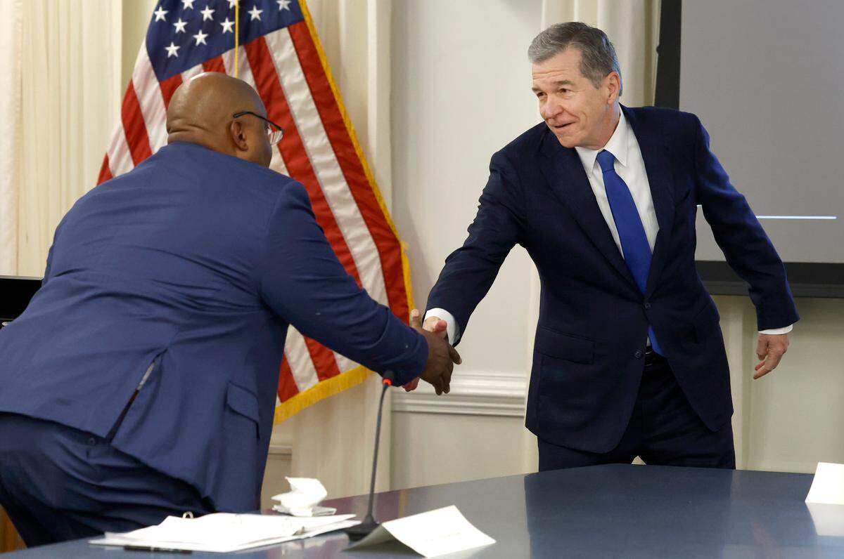 North Carolina Governor Roy Cooper, right, greets Lt. Gov. Mark Robinson, left, before the Council of State meeting in Raleigh, N.C., Tuesday, Jan. 9, 2024. Cooper, a Democrat, is finishing up his second term in 2024. Robinson, a Republican, is running for governor. Cooper endorsed Attorney General Josh Stein, who also serves on Council of State.