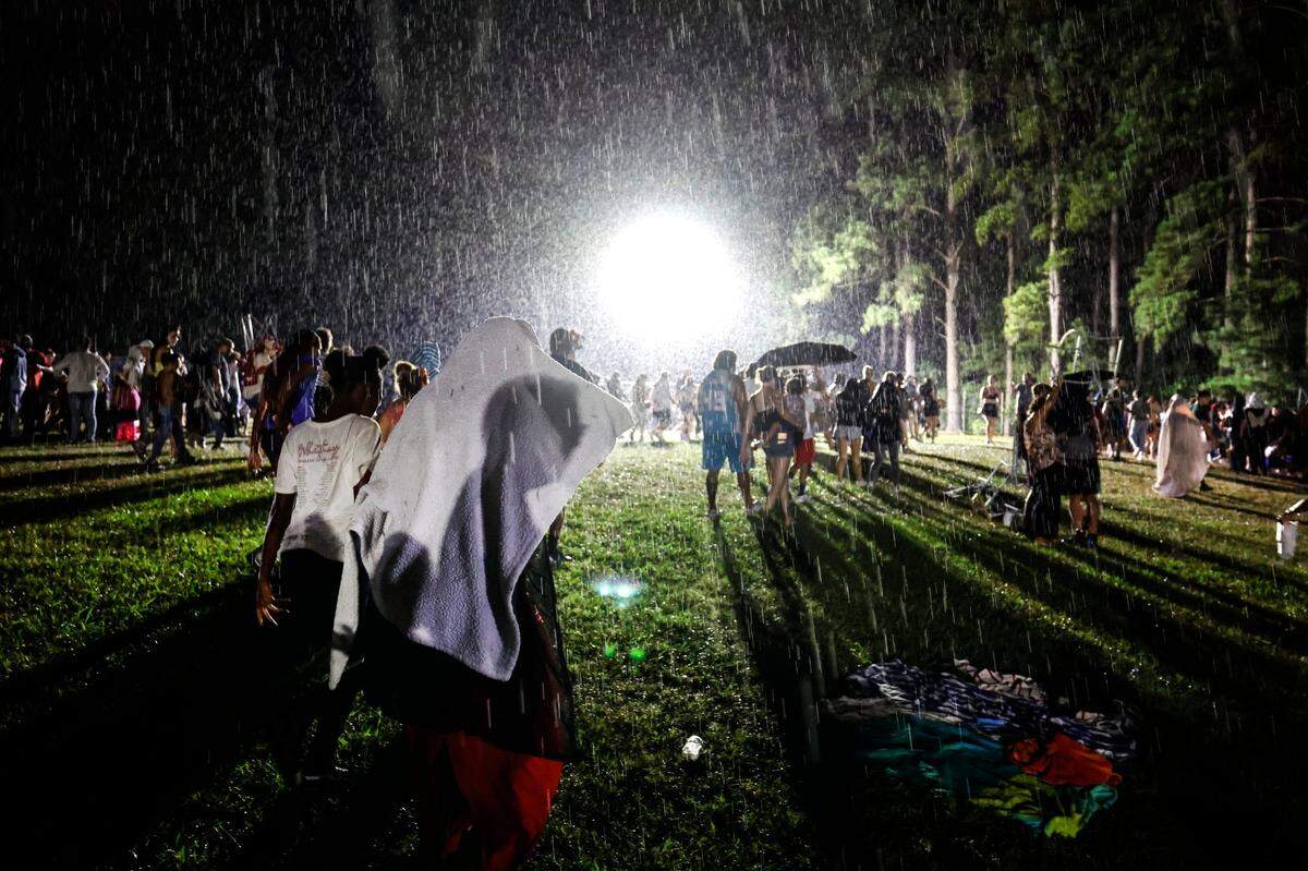 Attendees start to stream out of Dorothea Dix Park in Raleigh, N.C., after they were told to leave the area as a storm passes through minutes before the fireworks show was suppose to start Thursday evening, July 4, 2024. Attendees were then told they could stay as the rain got heavier.