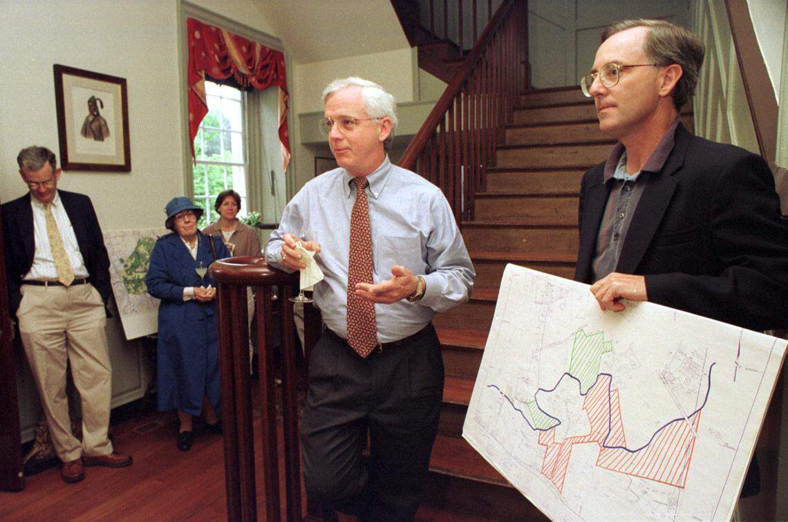 In this 1997 file photo, Preservation North Carolina executive director J. Myrick Howard, center, announces to a gathering the purchase by PNC and the Preservation Fund of Hillsborough a 165 acre tract of land along the Eno containing the site of the old Orange Co. racetrack. The historically significant acreage is directly across the Eno. At right, Bill Crowther, Ayr Mount site manager and chairman of the Orange Co. Bd. of Commissioners, holds a site plan showing the path of the Eno zig-zagging through Hillsborough, with the new tract highlighted in red lines on the south side of the river.