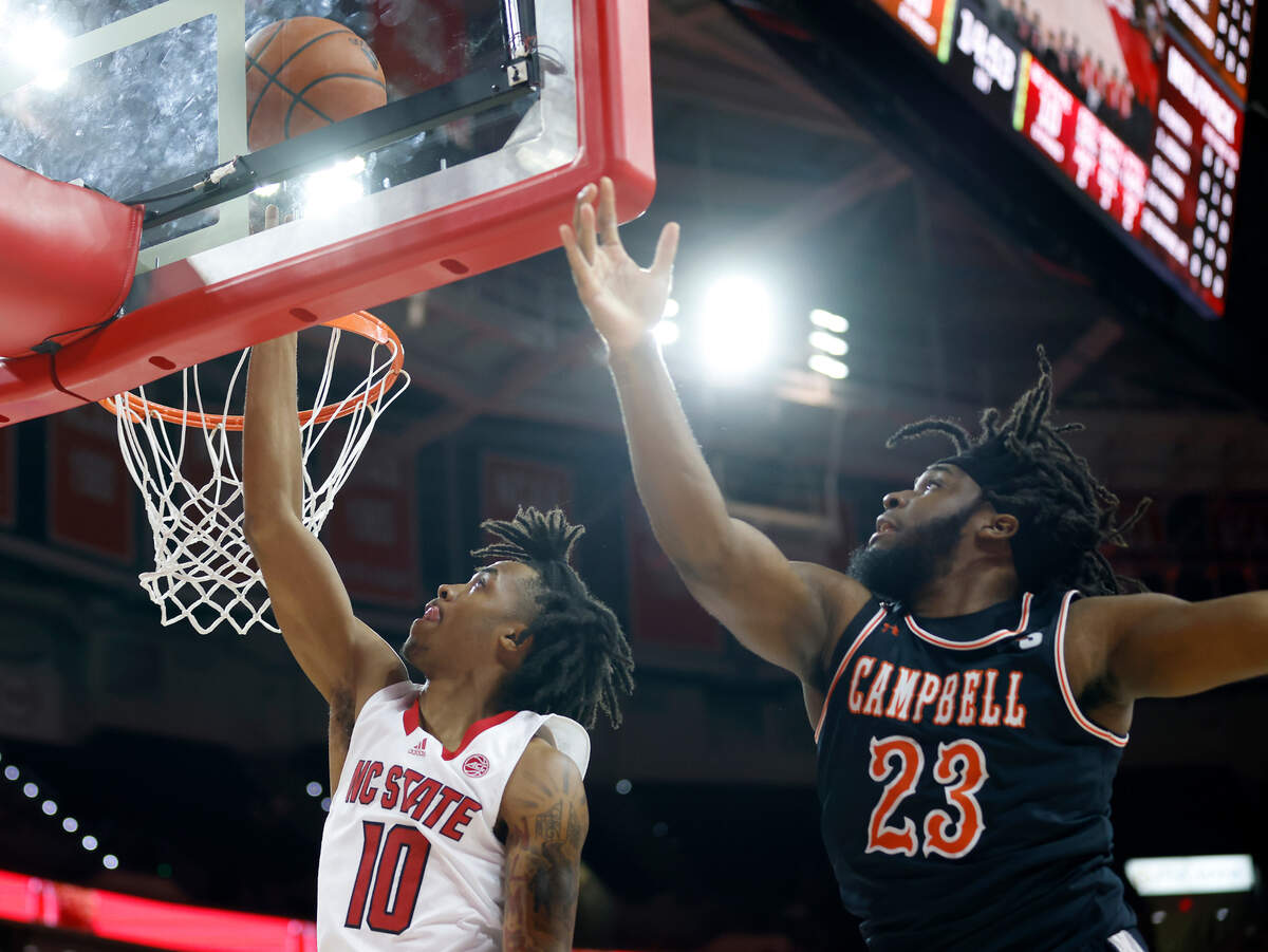 North Carolina State Wolfpack guard Breon Pass drives by Campbell Fighting Camels forward Joshua Lusane during the first half of a men’s basketball game at PNC Arena in Raleigh, N.C. on Friday, Nov. 11, 2022.
