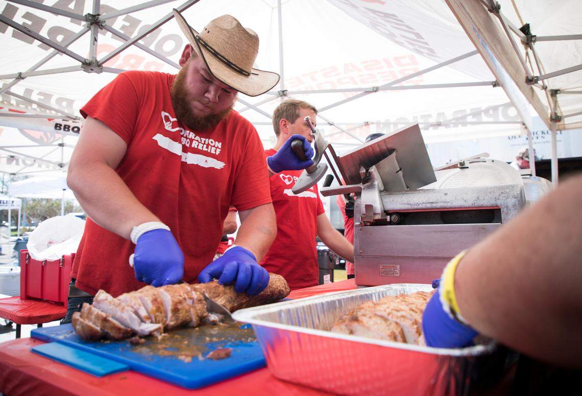 Joe Wilson, a volunteer from Fort Wayne, Indiana, chops up freshly smoked pork ahead of the dinner shift at the Operation BBQ Relief station in Wilmington on Wednesday, Sept. 19, 2018. The non-profit, based in Kansas City, Missouri, provides free barbecue meals after disasters all over the country.