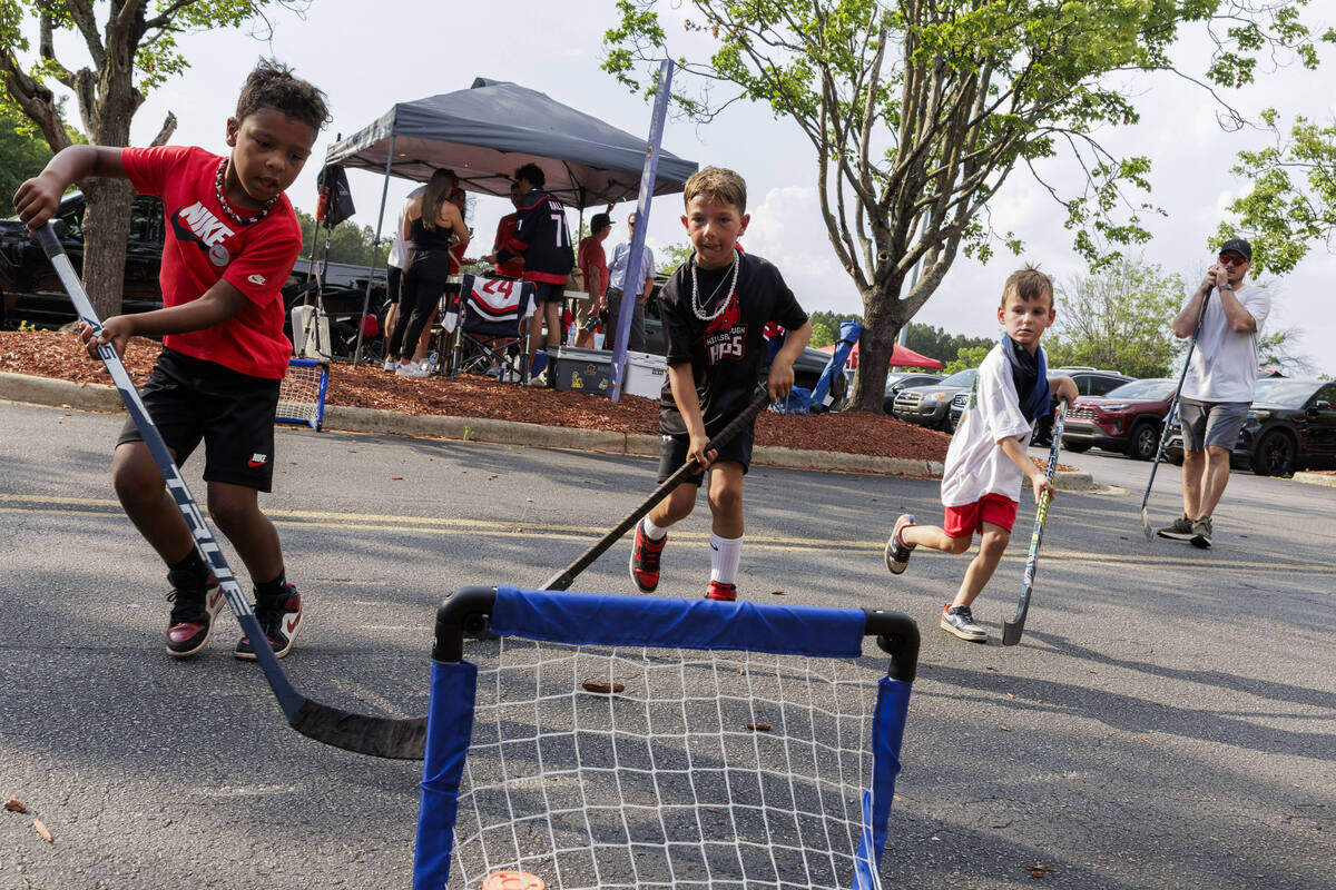 Xander Ham, Hudson Crucitti, and Rowan Dombroski play field hockey in the parking lot outside the Lenovo Center on June 11, 2026, in Raleigh, North Carolina. The Carolina Hurricanes take on the Vegas Golden Knights for Game 5 of the Stanley Cup Final.