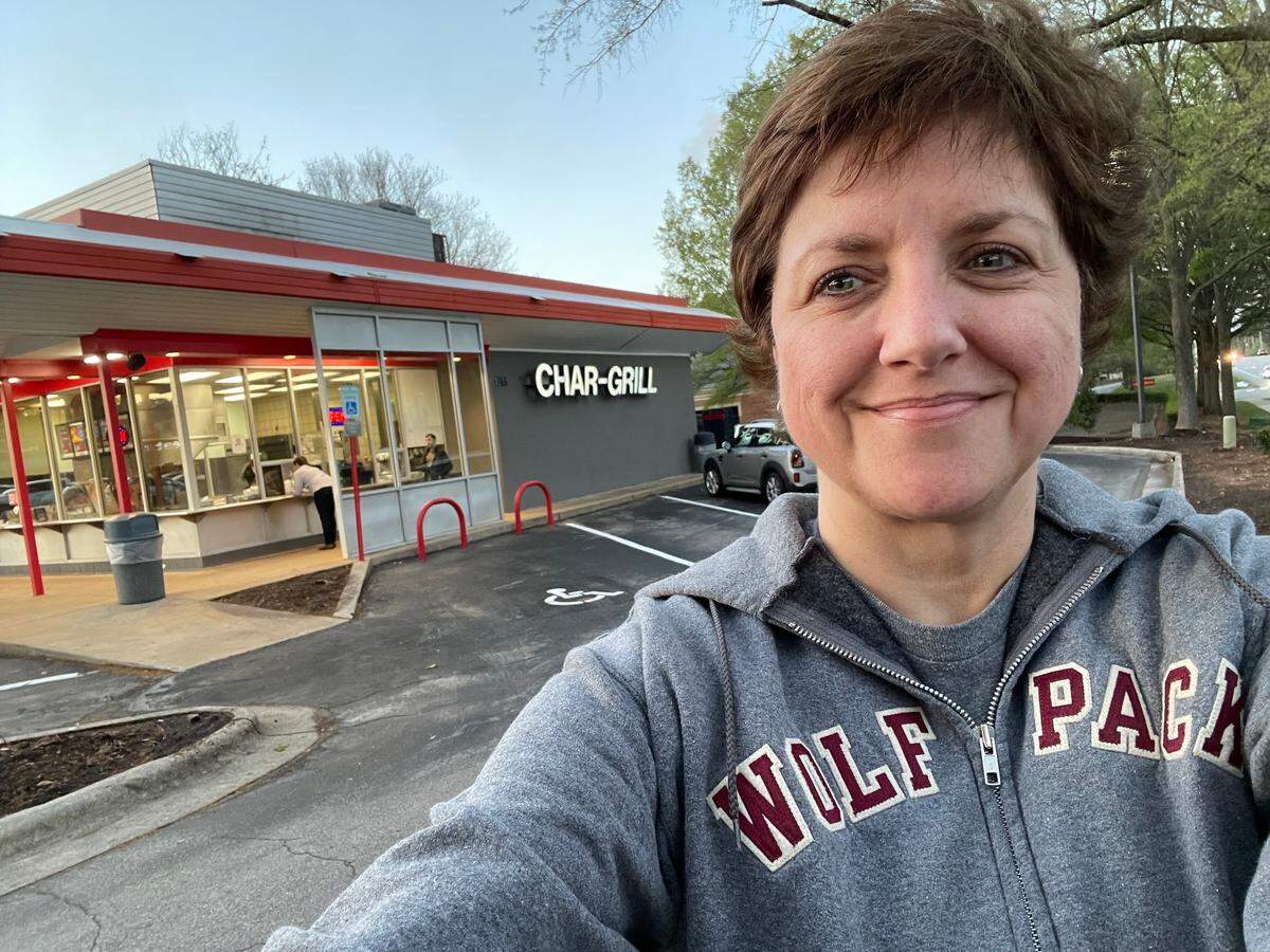 Superstitious NC State grad Brooke Cain in her lucky Wolfpack hoodie in front of Char Grill on Edwards Mill Road in Raleigh, where she orders her lucky game day meal when State’s basketball team plays in the NCAA tournament this year.