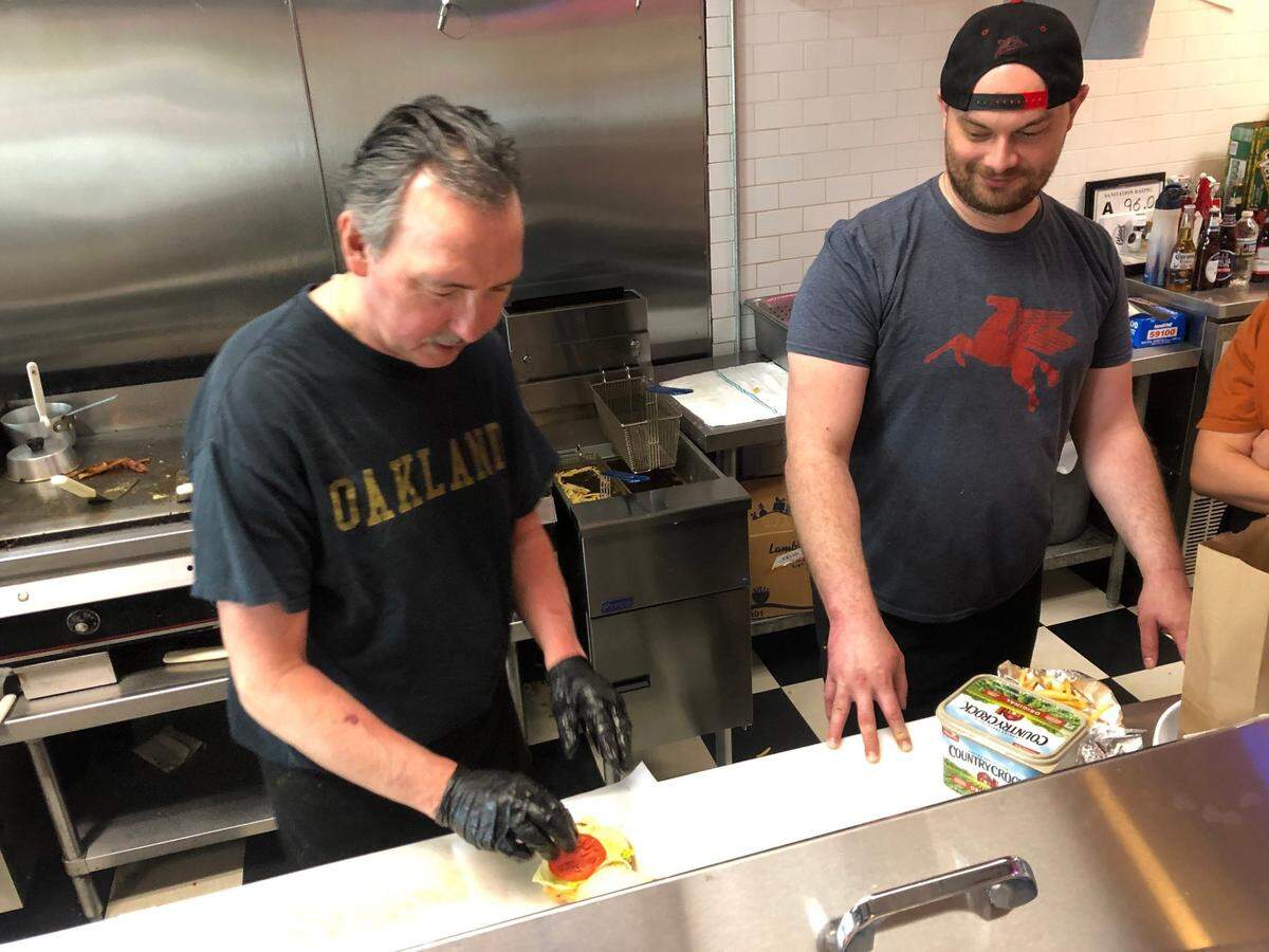 Dan Cloos (left) and his son Mark prepare orders at Cloos’ Coney Island on Friday.
