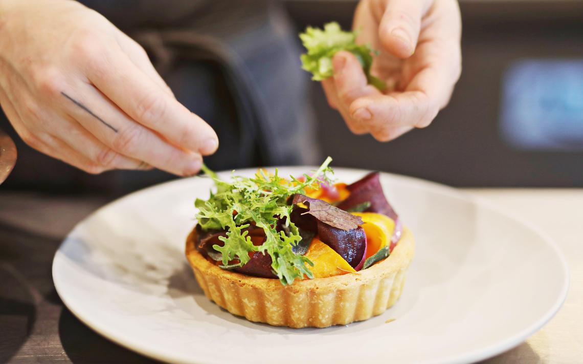 Jolie’s chef de cuisine Madison Tessener dresses the vegetable tart with an herb salad at the Raleigh restaurant on Wednesday, Nov. 13, 2019.