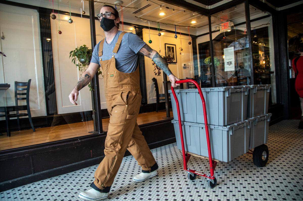 Owner Sunny Gerhart prepares to deliver a contract order of casseroles to Inter-Faith Food Shuttle Wednesday, Dec. 9, 2020 at St. Roch Fine Oysters + Bar in downtown Raleigh. Gerhart has a contract with the food shuttle funded by CARES Act money.