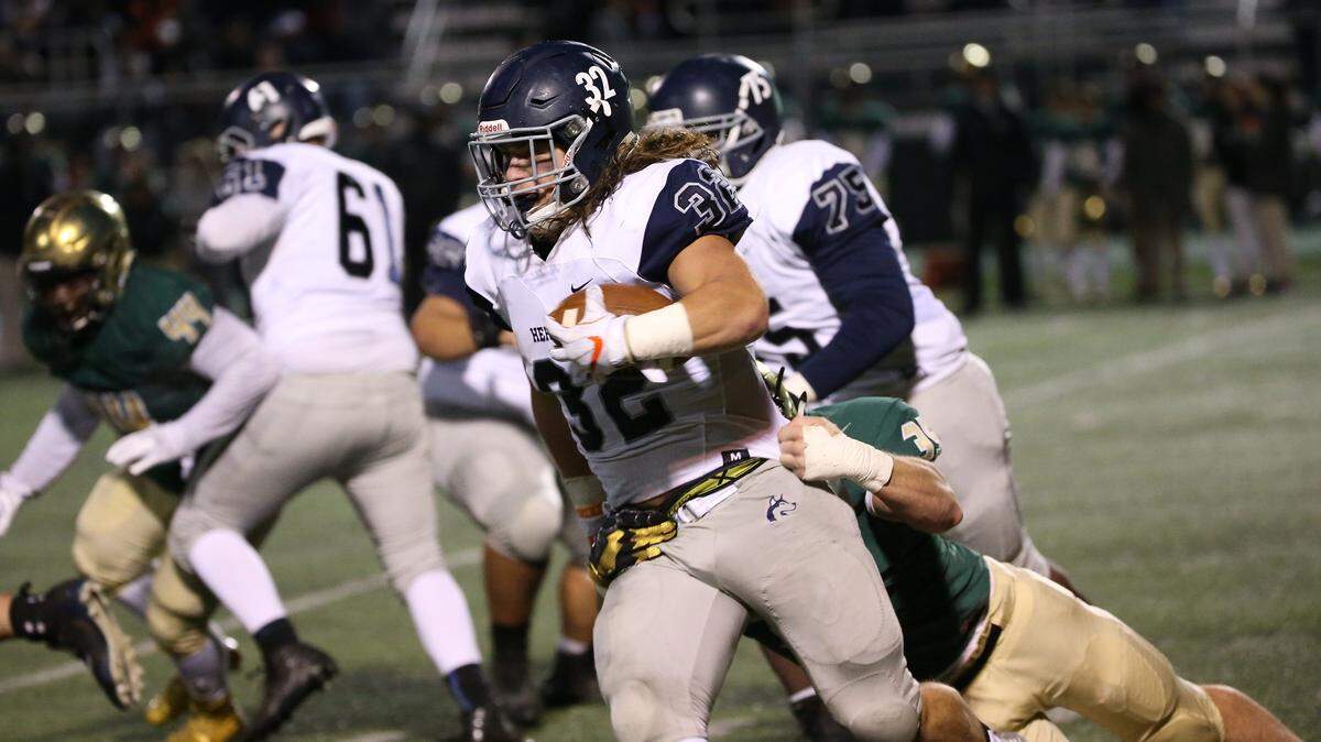 Heritage's Drake Thomas, middle, pulls Cardinal Gibbon's Brandon Hicks on this short run on Nov. 17, 2017. Thomas received an offer from Alabama this week.