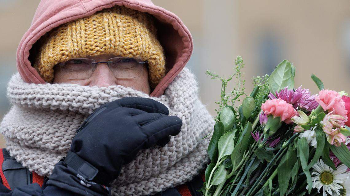 A person holds a bouquet of flowers while awaiting a procession of Buddhist monks at Dorothea Dix Park as a part of the Walk for Peace on Saturday, Jan. 24, 2026, in Raleigh, N.C.