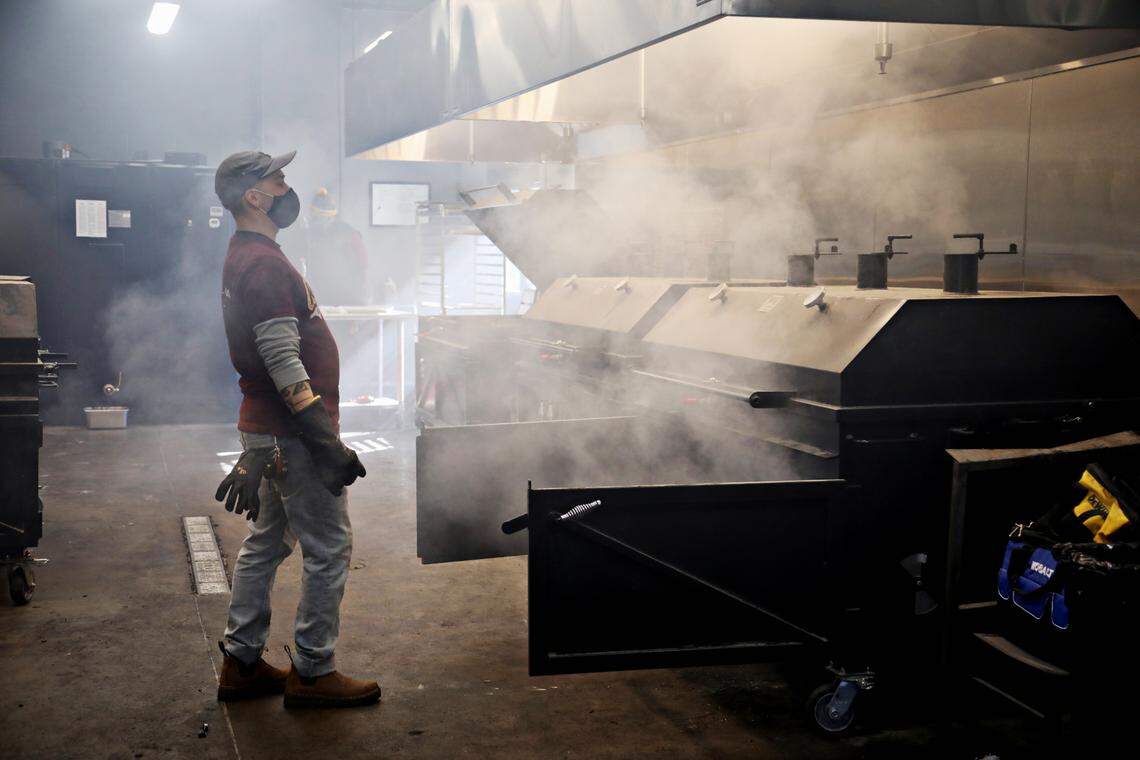 Sam Jones BBQ pit crew member Chris Wills steps back from the smoke as he works in the smokehouse in the new downtown Raleigh location on Wednesday morning, Feb. 3, 2021. The restaurant is starting off with a soft-open this week.