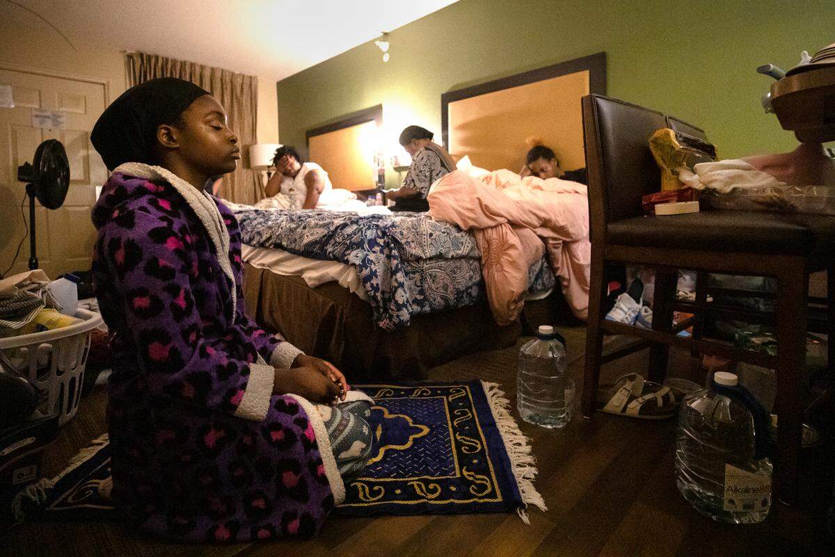 London Jones, 13, prays before going to bed at her family’s room at an extended-stay hotel in Raleigh, N.C. on Tuesday, July 5, 2022.