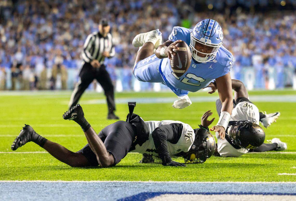 North Carolina quarterback Jacolby Criswell (12) dives over Wake Forest defensive back Zamari Stevenson (17) to score on a 4-yard run to give the Tar Heels a 7-3 lead in the second quarter on Saturday, November 16, 2024 at Kenan Stadium in Chapel Hill, N.C.