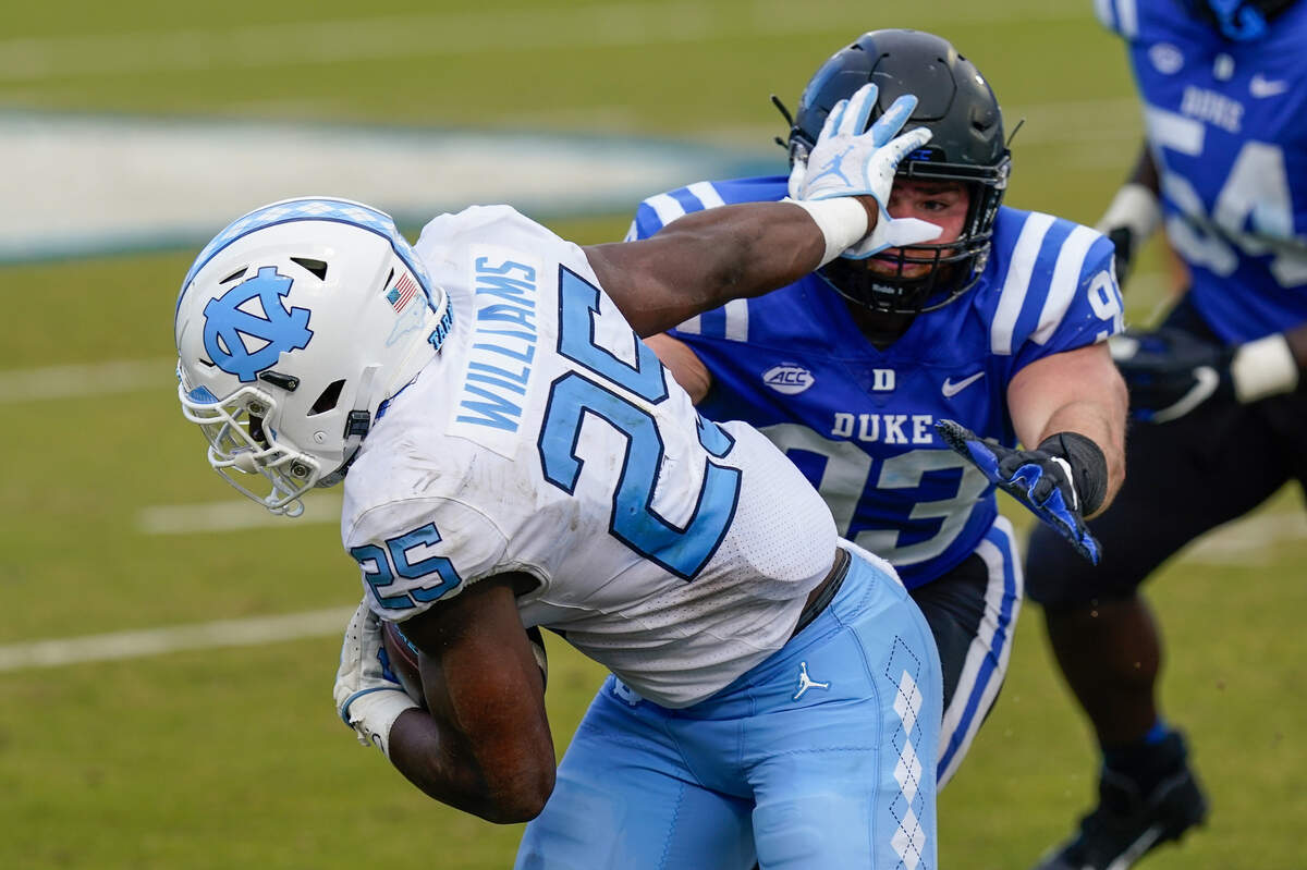 North Carolina Tar Heels running back Javonte Williams (25) pushes off of Duke Blue Devils defensive tackle Ben Frye (93) during the second half at Wallace Wade Stadium. 