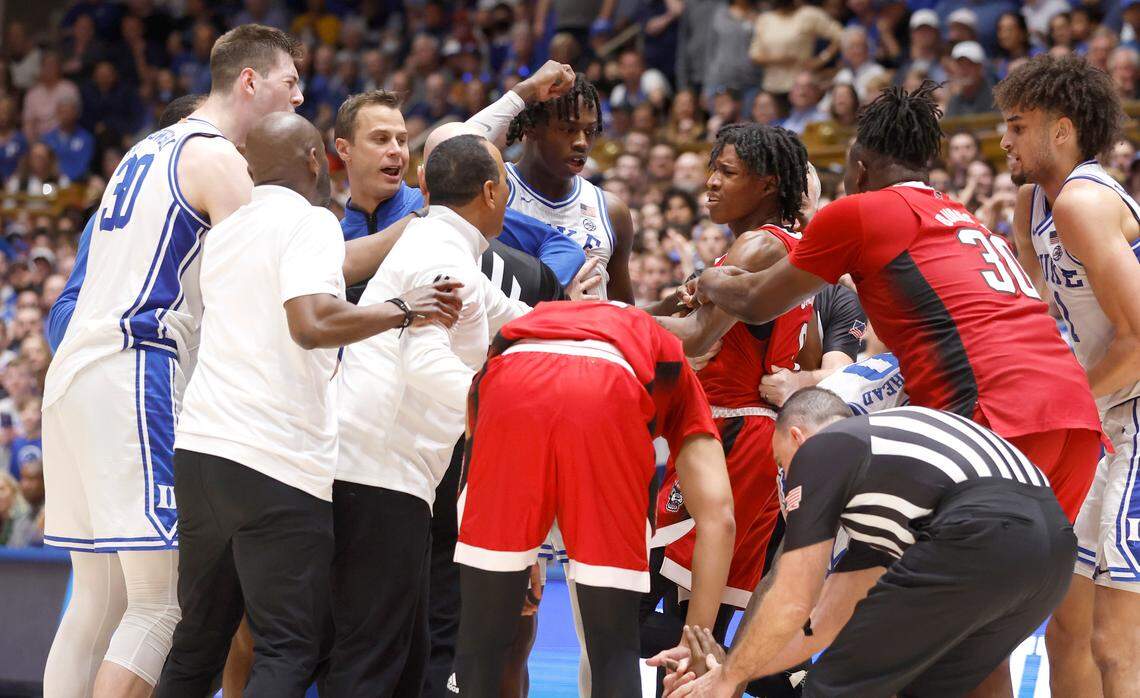 Duke head coach Jon Scheyer and N.C. State head coach Kevin Keatts come in between N.C. State’s Terquavion Smith (0) and Duke players during the second half of Duke’s 71-67 victory over N.C. State at Cameron Indoor Stadium in Durham, N.C., Tuesday, Feb. 28, 2023.