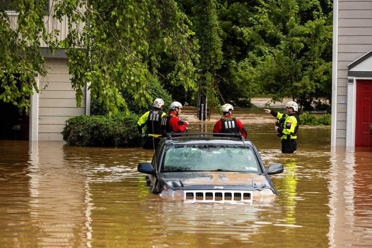 A water rescue unit with the Durham Fire Department knocks on doors at Rippling Streams Townhomes in the Old Farm neighborhood along the Eno River on July 7.