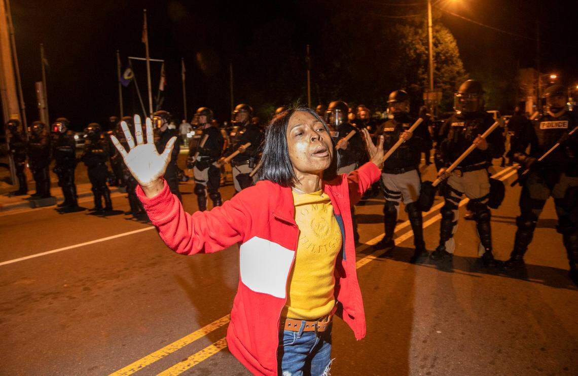 Andrew Brown Jr.Õs longtime partner Patrice Revelle raises her hands in front of a police line Tuesday, April 27, 2021 in downtown Elizabeth City. At least six demonstators were arrested when police in riot gear marched toward roughly a dozen protesters 2 hours past curfew. Protesters were peaceful but refused to clear the streets.