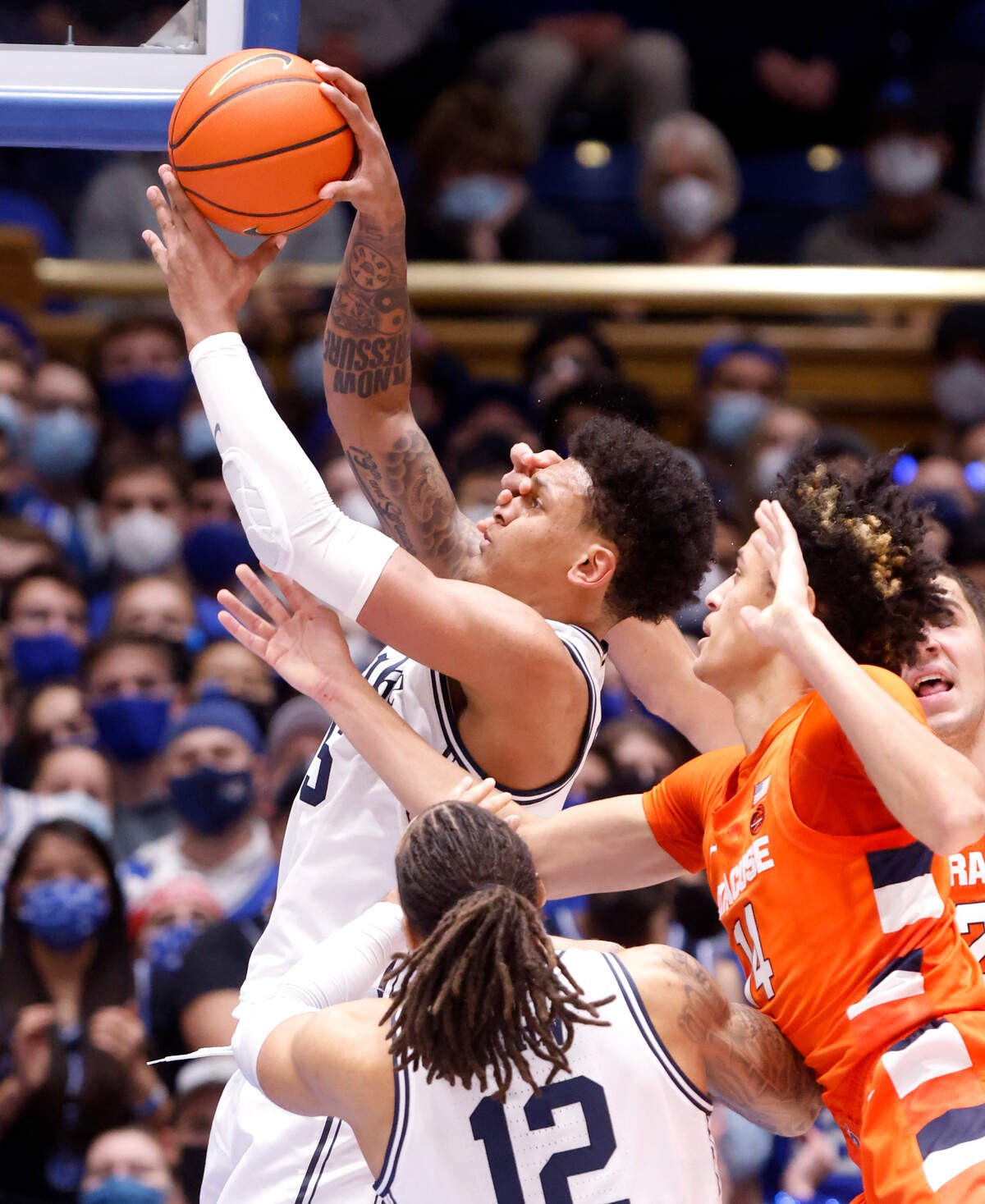 Duke’s Paolo Banchero (5) pulls in the rebound from Syracuse’s Jesse Edwards (14) and Cole Swider (21) during the first half of Duke’s game against Syracuse at Cameron Indoor Stadium in Durham, N.C., Saturday, Jan. 22, 2022.