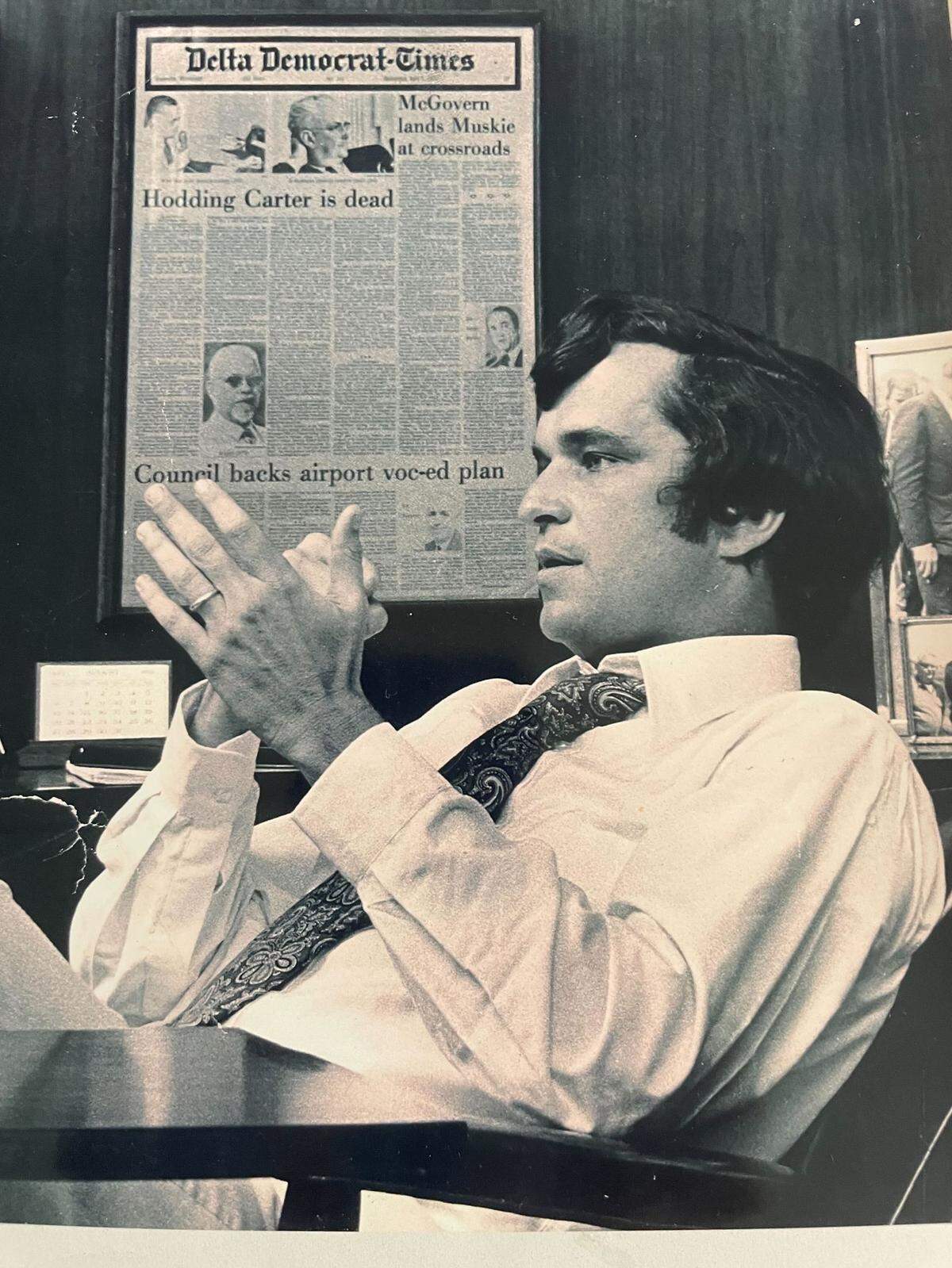 Hodding Carter III at the Greenville Delta Democrat Times office in the 1970s. His father, Hodding Carter Jr., was the founder of the paper, and an article about his death can be seen on the paper in the background of the photo.