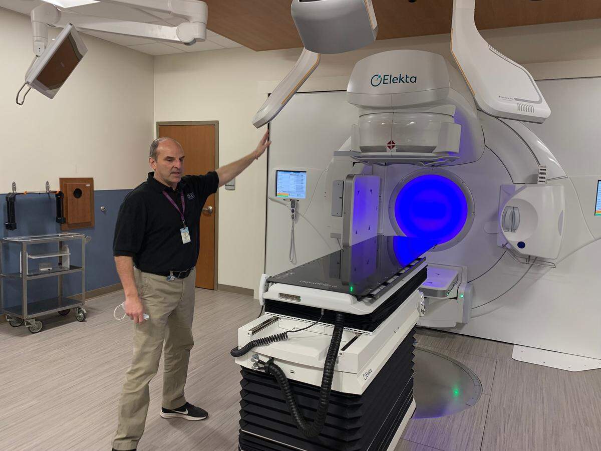 Don Roback, the chief medical physicist at UNC Rex Cancer Center, shows off one of two new radiation machines in the center, which opens March 1, 2022. A third radiation machine will be moved from the old center in the coming weeks.