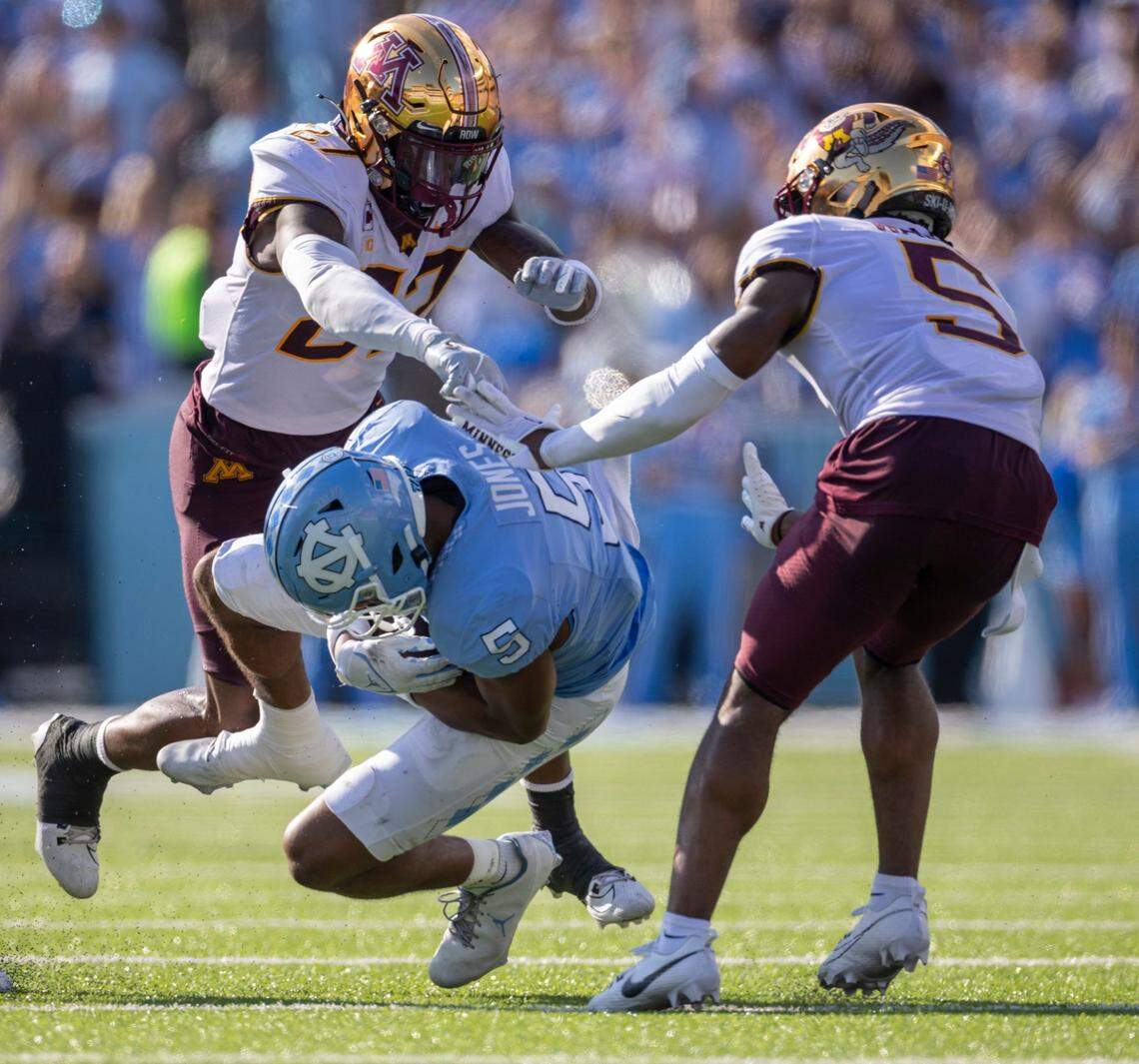 North Carolina’s J.J. Jones (5) is stopped by Minnesota’s Justin Walley (5) and Tyler Nubin (27) after a 39-yard pass reception from quarterback Drake Maye to set up a touchdown in the second quarter on Saturday, September 16, 2023 at Kenan Stadium in Chapel Hill N.C.
