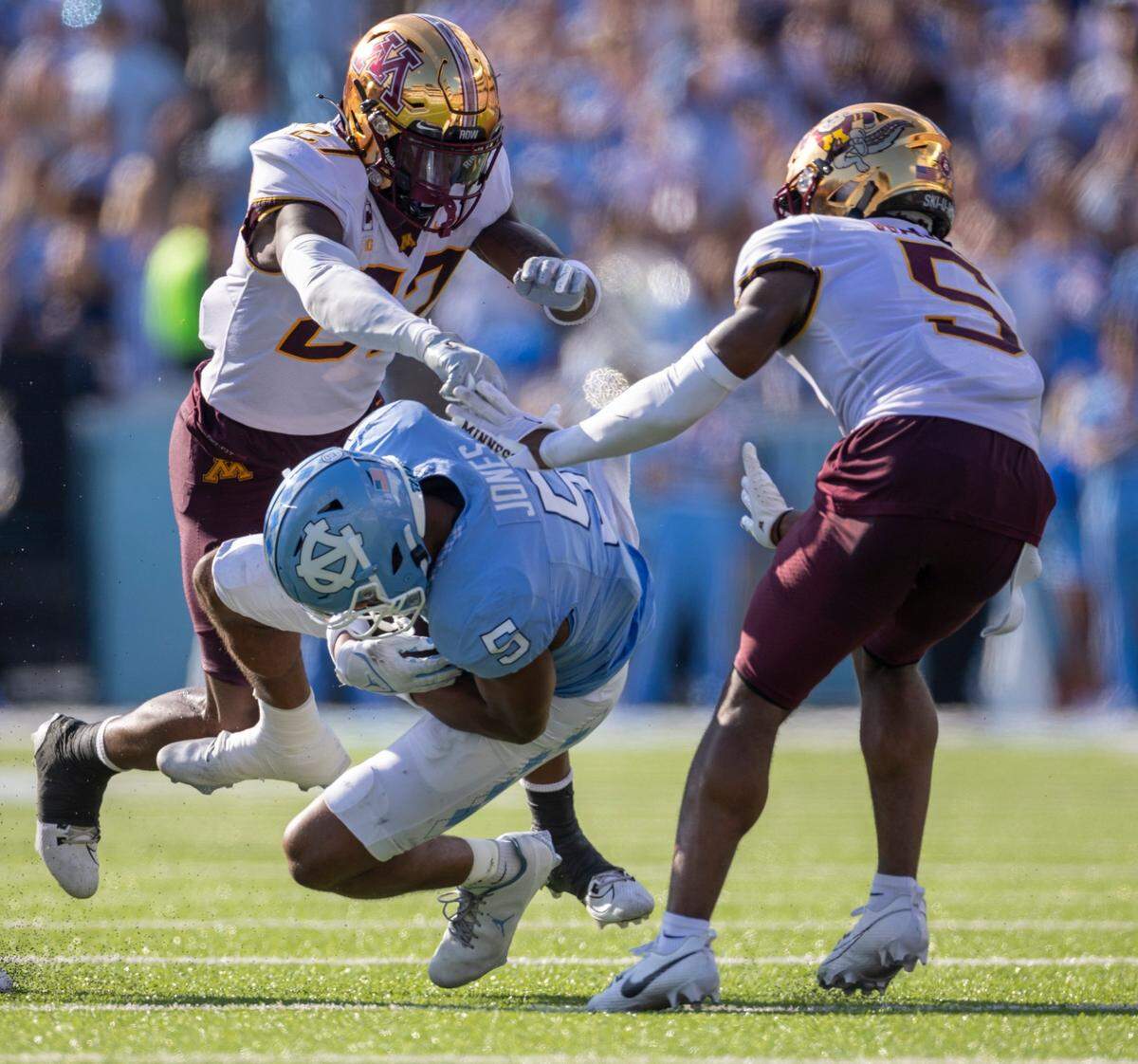 North Carolina’s J.J. Jones (5) is stopped by Minnesota’s Justin Walley (5) and Tyler Nubin (27) after a 39-yard pass reception from quarterback Drake Maye to set up a touchdown in the second quarter on Saturday, September 16, 2023 at Kenan Stadium in Chapel Hill N.C.