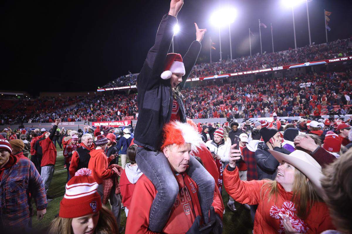 Wolfpack fans storm the field to celebrate their 34-30 victory over North Carolina on Friday, November 26, 2021 at Carter-Finley Stadium in Raleigh, N.C.