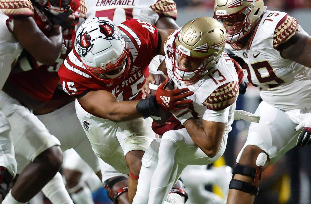 N.C. State defensive tackle Davin Vann (45) sacks Florida State quarterback Jordan Travis (13) during the first half of N.C. State’s game against Florida State at Carter-Finley Stadium in Raleigh, N.C., Saturday, Oct. 8, 2022.