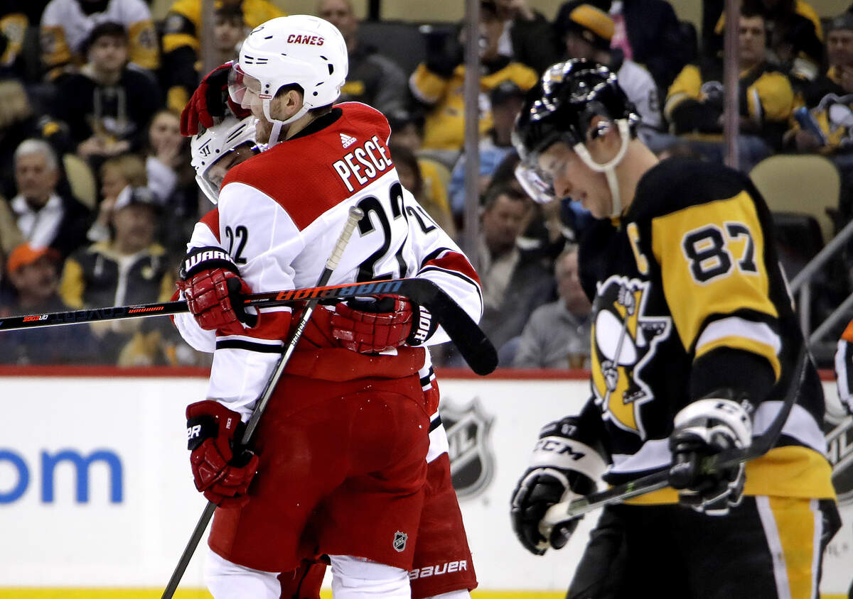 Carolina Hurricanes’ Brett Pesce (22) celebrates his goal with Sebastian Aho, left, as Pittsburgh Penguins’ Sidney Crosby (87) skates back to his bench during the second period of an NHL hockey game in Pittsburgh, Tuesday, Feb. 5, 2019. (AP Photo/Gene J. Puskar)