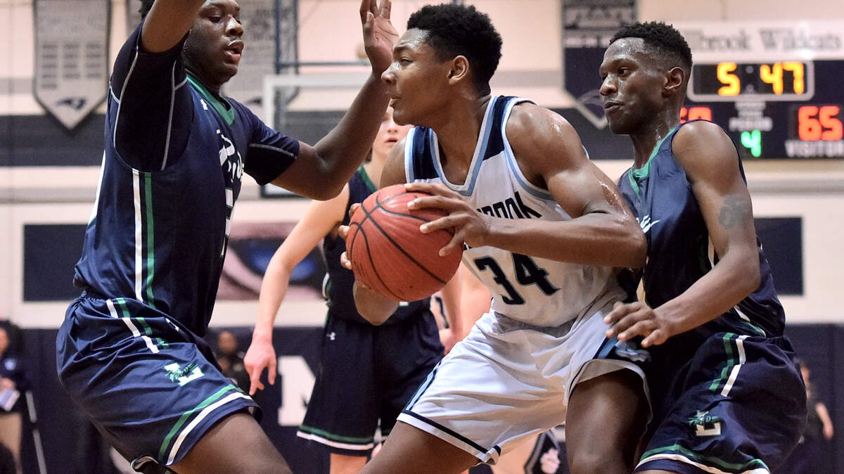 Leesville Road’s Deon Daniels (14) and RJ Wilson (24) defend Millbrook’s William Felton (34). The Leesville Road Pride and the Millbrook Wildcats met in the Cap-7 basketball semi-finals in Raleigh, N.C. on February 21, 2019.