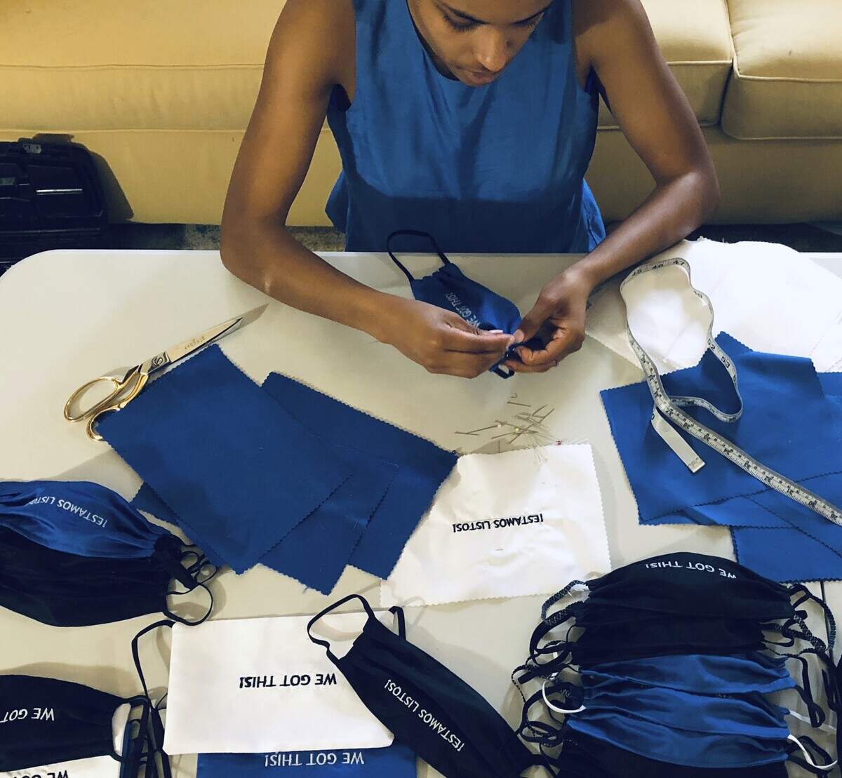 In this Sunday, March 22, 2020, photo, provided by Christina Hunter, Briana Danyele sews cloth face masks that say “We Got This!” in her mother’s living room in Greer, S.C., which will be sent to health care workers. Legions of everyday Americans are sewing masks for desperate hospitals, nursing homes and homeless shelters amid the expanding coronavirus pandemic. (Christina Hunter via AP)