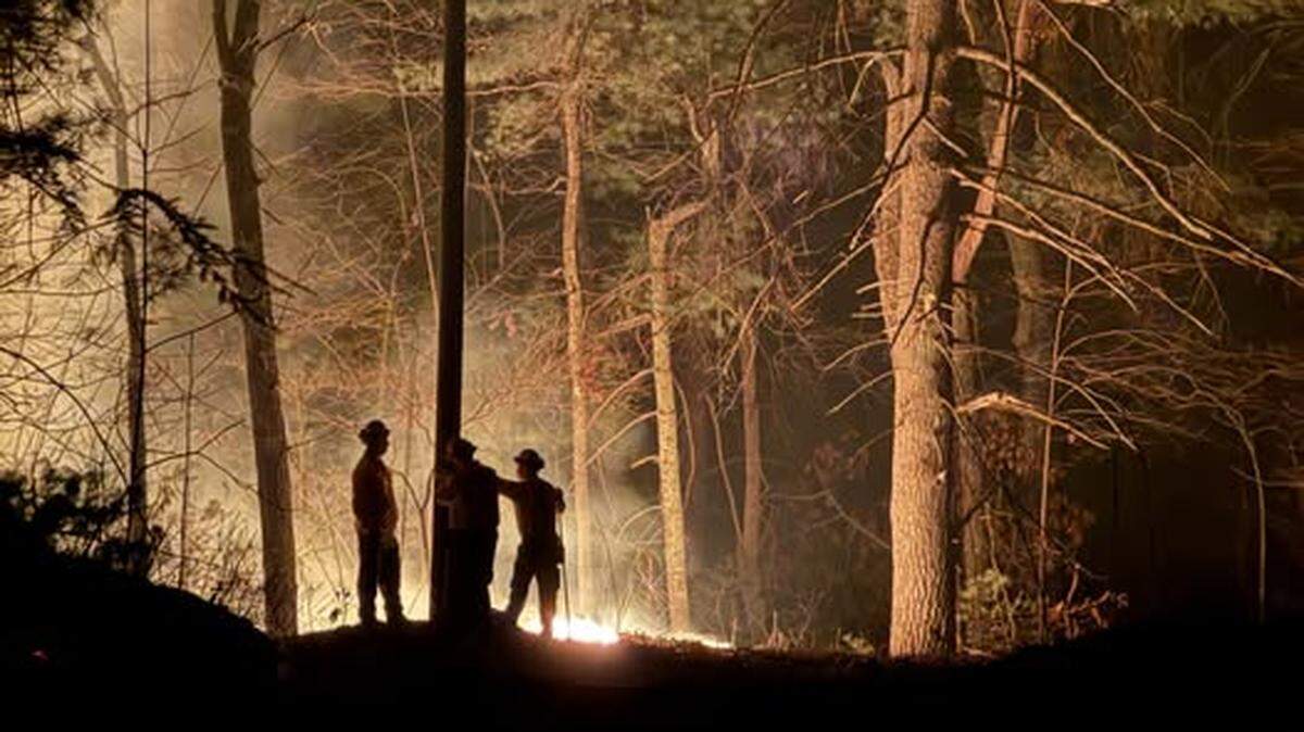 Dry conditions across most of North Carolina have contributed to a busy fire season in Spring 2025. As of Monday, May 5, dozens of fires were burning across the state, including on in Brunswick County that has torched 1,369 acres so far. Here, firefighters work to contain the Black Cove fire in Polk County in March 2025.