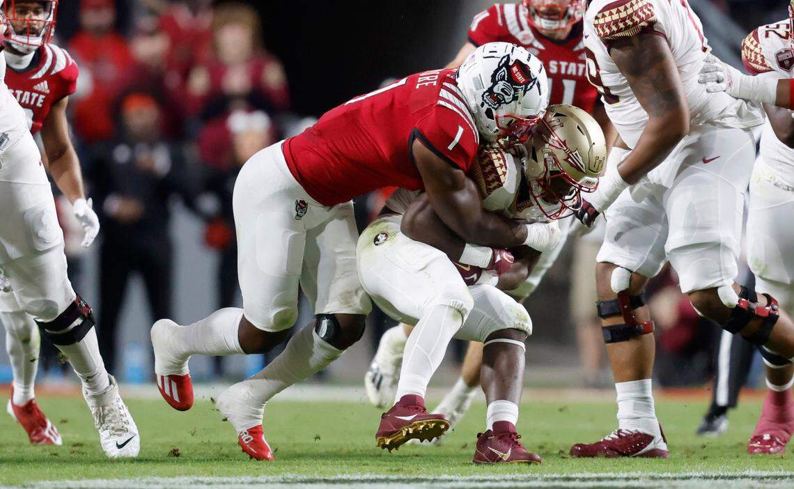 N.C. State linebacker Isaiah Moore (1) tackles Florida State running back Trey Benson (3) during the first half of N.C. State’s game against Florida State at Carter-Finley Stadium in Raleigh, N.C., Saturday, Oct. 8, 2022.