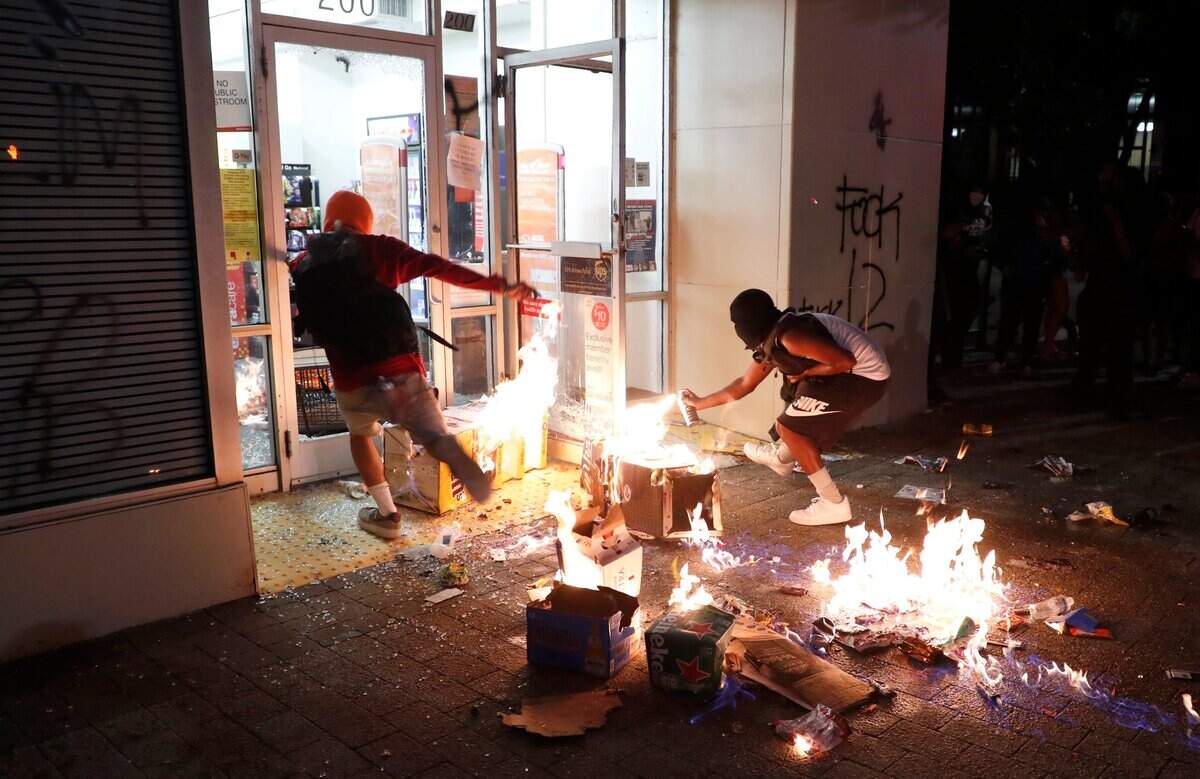 Protesters burn items in front of the CVS Pharmacy in downtown Raleigh, N.C. Saturday, May 30, 2020.