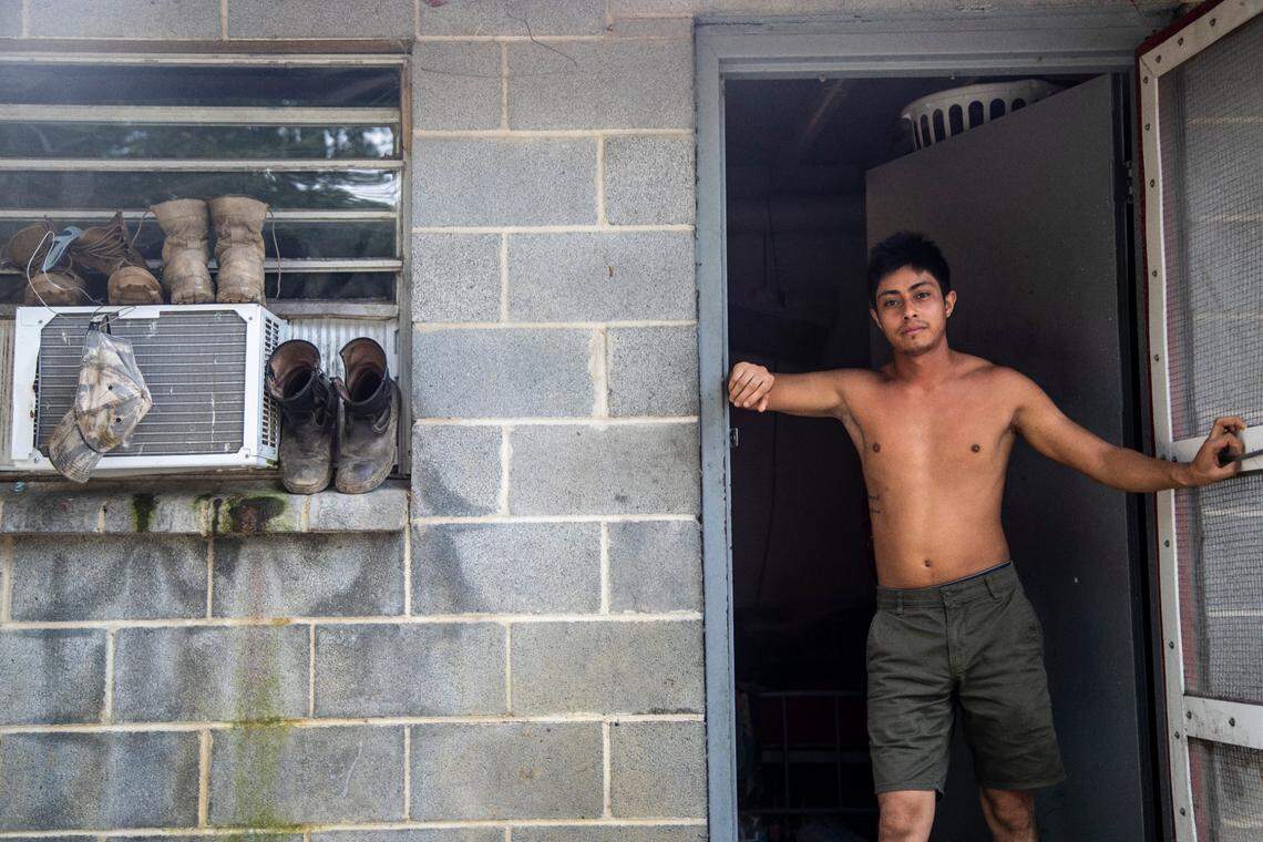 A farmworker named Javier stands in the doorway of his living quarters at a Johnston County farmworker camp Thursday August 27, 2020. Air conditioning is considered a luxury by many farmworkers in North Carolina farmworker camps.